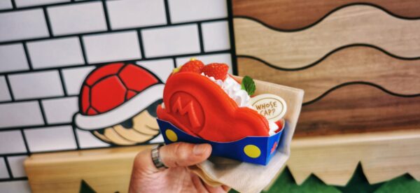 Un dessert qui ressemble à la casquette de Mario (Nintendo) avec un décors évoquant le jeu vidéo en arrière plan.