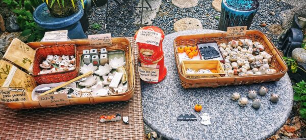 Un stand d'objet à vendre dans la rue devant la maison d'un local. L'inscription en anglais : prenez ce que vous voulez et mettez l'argent dans la boîte.