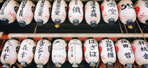 Des lampions en plein jour avec des inscriptions en japonais. Une inscription en français ressort : bisous